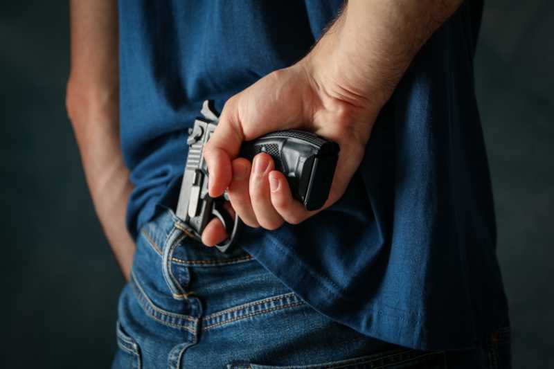 A Man Hold A Gun From Behind representing Weapons Charges